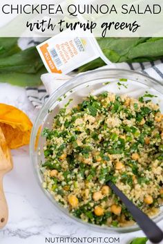 chickpea quinoa salad with turnip greens in a glass bowl on a marble counter