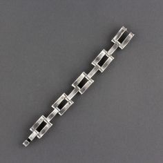 This is a great Mid Century Modernist Mexican Taxco sterling silver hidden closure link bracelet. The sterling bracelet has ten slightly curved hinged sections. The design alternates between one and then two pieces. They are connected by a pin and the movement is supple and easy. There is a incised line and circle pattern on each piece. The bracelet has a hook and bar clasp that is hidden when worn. The silver is even, and any variance is a reflection. A nice size, as worn it measures 7 3/8 inch Modern Jewelry With Rectangular Links For Formal Occasions, Contemporary Formal Bracelet With Oyster Design, Modern Link Bracelets With Polished Finish, Modern Sterling Silver Oyster Bracelet For Formal Occasions, Modern Polished Sterling Silver Bracelet, Modern Sterling Silver Jubilee Bracelet With Rectangular Links, Formal Sterling Silver Bracelet With Rectangular Links, Modern Sterling Silver Bracelet For Formal Occasions, Contemporary Formal Oyster Bracelet