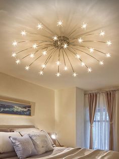 a large bed sitting under a ceiling light in a bedroom