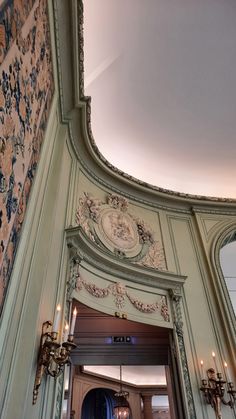 an ornately decorated entrance to a building with chandeliers on the wall and ceiling