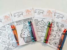 four coloring books with colored crayons on them