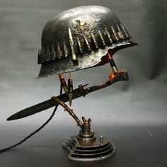 a metal helmet on top of a table with a cord plugged in to it