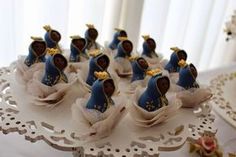 there are many small figurines on the cake plate with ribbons around them that look like angels