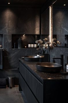 a black bathroom with two sinks and candles