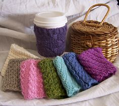 there is a cup and some knitted items on the bed