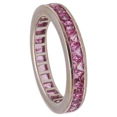 An eternity ring with Pink Sapphires. A classic modern full eternity band carefully crafted in solid white gold of 18 karats, with high polished finish. Pink Sapphires: Mounted in a channel setting, with 27 calibrated French squared steps cuts of pink Sapphires with a weight of 2.70 carats. The gemstones are natural, fully transparent, from Madagascar, earth mined and vivid pink color. Weight: 2.95 Grams (1.89 Dwt,). Size: 5.5, sizeable. The width measure is 4 mm (0.16 Inch). Hallmarks: Stamped Platinum Eternity Band With Channel Set, Platinum White Gold Eternity Band With Channel Set, Eternity Rings Stackable, Channel Setting, Full Eternity Ring, Eternity Band Ring, Pink Ring, Classic Ring, Eternity Band