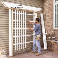 a man is working on a white door outside the house that's being built