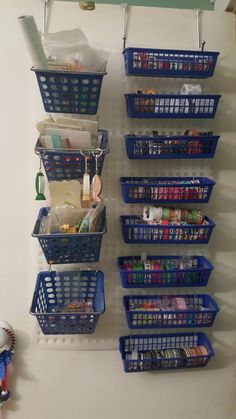 several baskets are hanging on the wall with hooks and clips to hold items in them