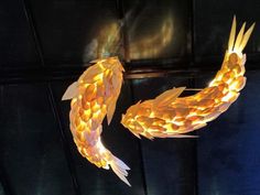 two paper fish are hanging from the ceiling