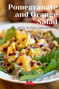 pomegranate and orange salad with dijon vinaigrete on a white plate