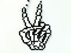 a black and white beaded peace sign hanging on a wall