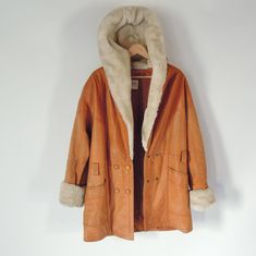 "Brand: Wilsons the Leather Experts 1990's Vintage Caramel Color brown leather Huge Acrylic pile Faux Fur lined hood, shawl collar and wrists The faux fur is a heavy thick pile Double breasted Deep V neck design has pockets missing belt if there was one (has loops) Some fading and a small pea size stain on one arm and the overall look is a bit weathered but looks so cool this way. Don't buy if you are expecting perfection. The pile faux fur on the wrists is a bit grungy and could use a dry clean Vintage Leather Jacket For Winter, Brown Hooded Leather Jacket With Faux Fur Lining, Retro Leather Winter Outerwear, Retro Leather Outerwear For Winter, Vintage Leather Jacket For Cold Weather, Vintage Leather Outerwear For Cold Weather, Hood Shawl, Fur Cuffs, Pastel Plaid