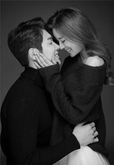 black and white photo of a couple embracing each other with their arms around one another