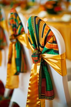 the chairs are decorated with gold and green ribbons on each chair's back end