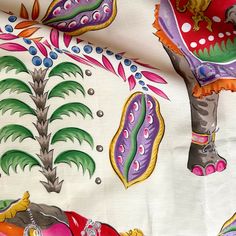 an elephant is painted on a white fabric with colorful designs and colors, as well as palm trees