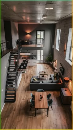 an aerial view of a living room and dining area with stairs leading up to the second floor