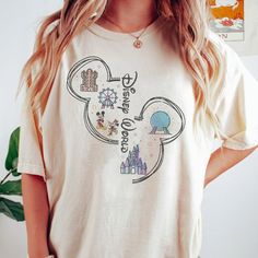 a woman wearing a mickey mouse tshirt standing in front of a white wall