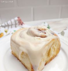 a white plate topped with a pastry covered in icing