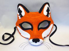 a red fox mask with white and black eyes