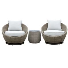 two wicker chairs with white pillows and a small table on the ground next to them