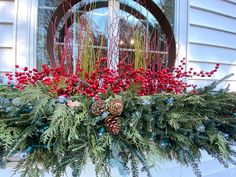 a christmas window box with pine cones and berries