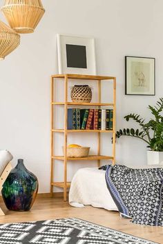 a living room filled with lots of furniture next to a wall mounted book shelf and potted plant