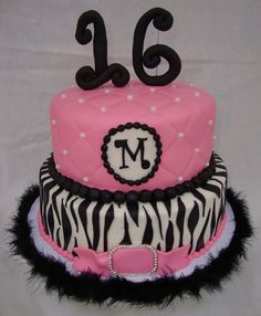 a pink and black cake with zebra print on the top, decorated with a number