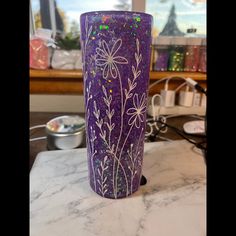 a purple vase sitting on top of a marble counter