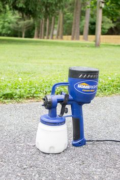 a blue and white paint sprayer sitting on the ground