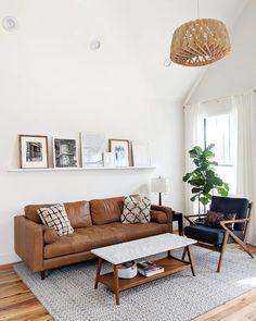 a living room filled with furniture and pictures on the wall next to a coffee table