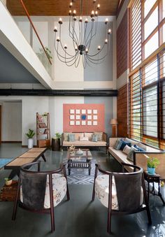 a living room filled with lots of furniture next to a tall wooden beamed ceiling