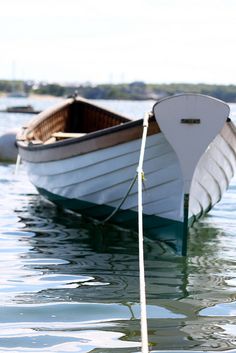 a small white boat floating on top of a body of water