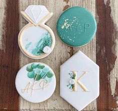 three decorated cookies sitting on top of a wooden table next to green and white icing