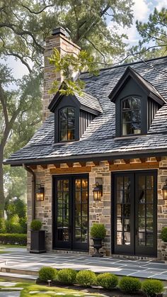 a stone house with black shingles and windows