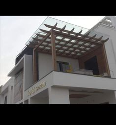 an outside view of a building with a glass roof and wooden slats on top