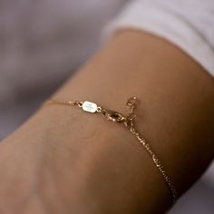 a person wearing a gold bracelet with a heart on it