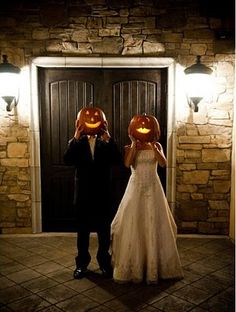 two people wearing pumpkin heads standing in front of a door with lights on their heads