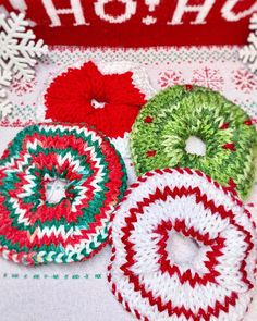 four crocheted donuts sitting on top of a table next to snowflakes