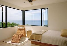 a bedroom with large windows overlooking the ocean