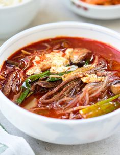 a white bowl filled with meat and vegetables