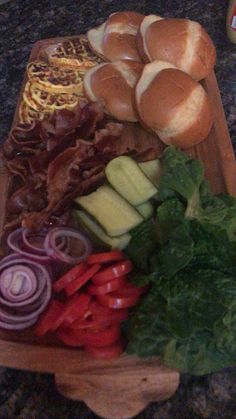 an assortment of breads and vegetables on a cutting board