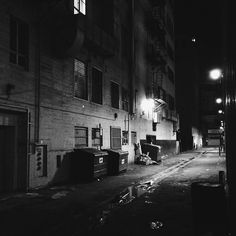 an empty alley at night with no one on the street or in front of it