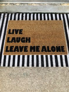 a door mat that says live laugh leave me alone on the side of a sidewalk