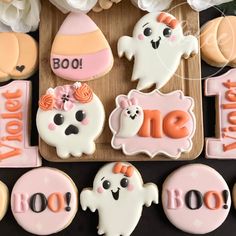 decorated cookies with the words boo and ghost on them are displayed in front of flowers