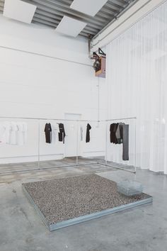 an empty room with clothes hanging on the wall and two shirts hung up to dry