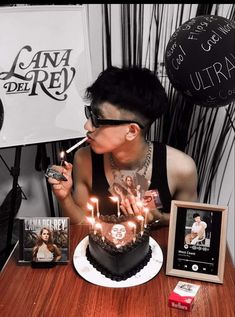 a man sitting at a table with a cake and candles in front of his face