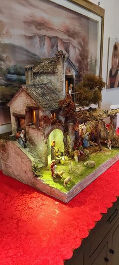 a table topped with a miniature house and trees