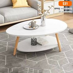 a white coffee table sitting on top of a rug in front of a gray couch