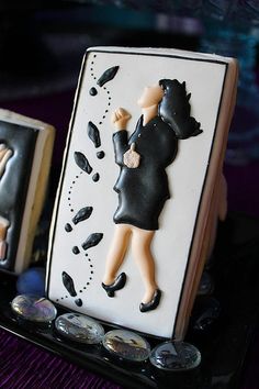 there is a decorated cookie with a woman holding a umbrella on it's side