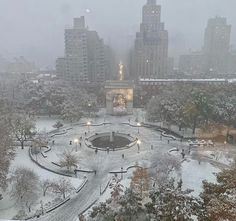 a city park is covered in snow and surrounded by tall buildings